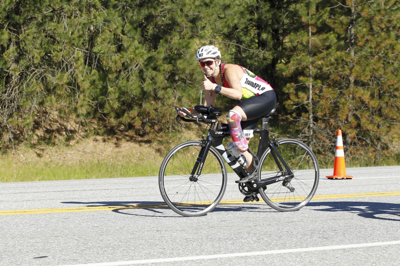 Emily on her bike giving the camera a thumb's up while on course at IM70.3 Coeur d'Alene in June of 2016